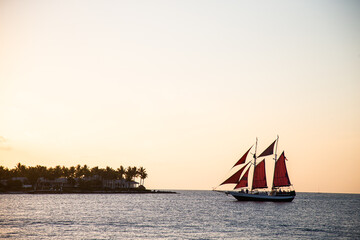 Sailboat crossing the horizon in the  late evening