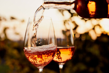 Wall Mural - Pouring rosé wine into glasses outdoors at a garden party