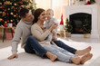 © New Africa - Happy family with cute baby on floor in room decorated for Christmas