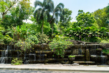 Water Pouring Off Rock A Feature In Front Of Trees At The Perdana Botanical Garden, - Kuala Lumpur, Malaysia.