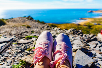 Sticker - Female legs in sneakers against coast landscape, Spain.