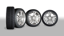 Set Of Four Wheels On Grey - White Background. New Tires On Aluminum Wheel Rims. No Logo Visible, Only Tire Labeling Visible.