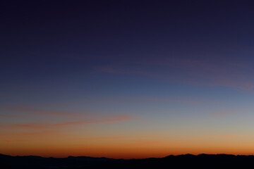 Heaven at early morning with copy space. Sunset, sunrise backdrop.Predawn clear sky with orange horizon and blue atmosphere. Smooth orange blue gradient of dawn sky.