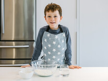 Smiling Boy With Bowl Of Flour In Kitchen