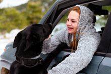 Dog On Hind Paws Caressing Woman Sitting In Car