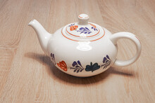 Traditional Dutch Teapot With A Hand-painted Farmer's Pattern ('boerenbont') On A Wooden Table.