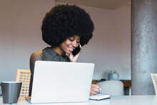Happy Black Woman Writing In Notebook Near Laptop