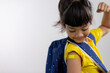 © FAMILY STOCK - Asian young girl showing her arm with yellow bandage after got vaccinated or inoculation, child immunization, covid delta vaccine concept
