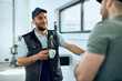 © Drazen - Happy mechanic talks to his coworker during coffee break at auto repair shop.