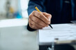 © Drazen - Close-up of mechanic filling paperwork while working at auto repair shop.
