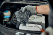 © Drazen - Close-up mechanic of checks oil level during engine maintenance in workshop.