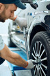 © Drazen - Close-up of auto repairman changes tire at car service workshop.