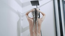 model showering in bathroom washing long hair with shampoo bath at home