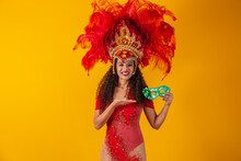 Young Afro Woman In Samba And Carnival Outfit Holding A Green Mask Smiling At The Camera.