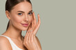 © Utkamandarinka - Beauty healthy skin women touching face cosmetic studio portrait. Sportswear color background green