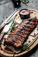 Wall Mural - Pork ribs grilled with BBQ sauce. Tasty snack on wooden board. Food recipe background. Close up