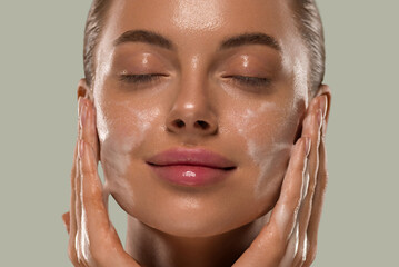 Wall Mural - woman face mask wash soap close up clean skin. color background green