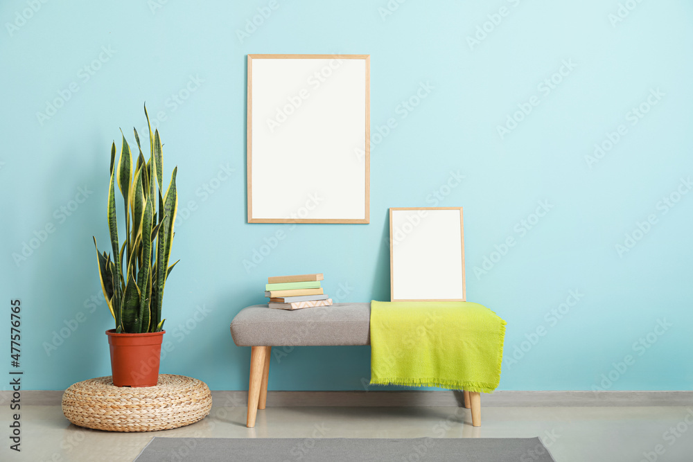 Stylish bench near color wall with blank poster