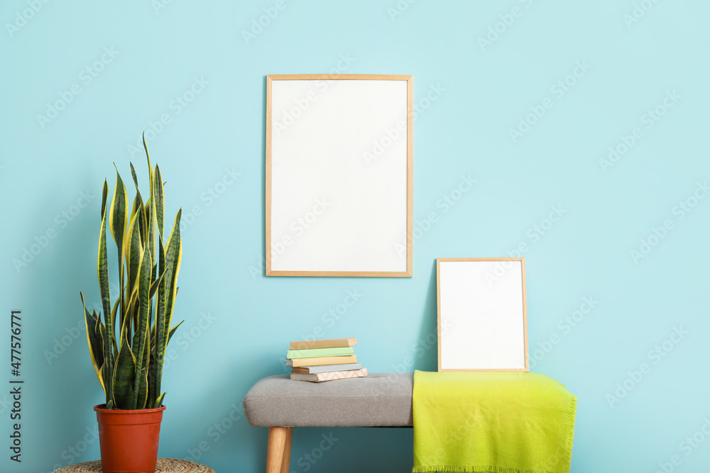 Stylish bench near color wall with blank poster