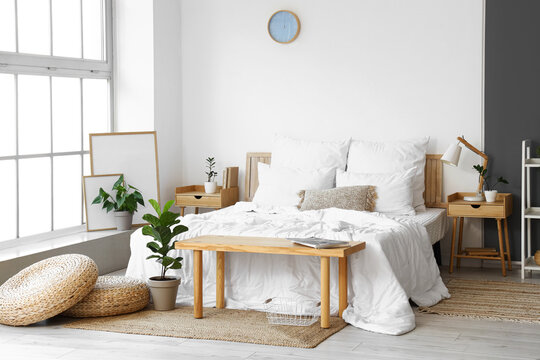 Interior of light modern bedroom with wooden tables