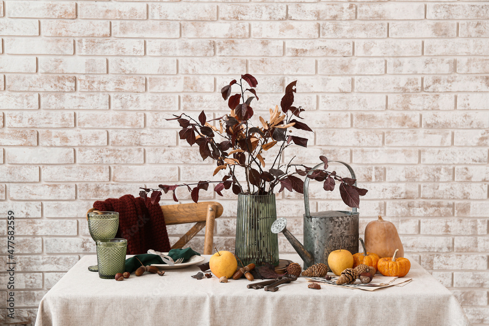 Beautiful autumn composition on table near light brick wall