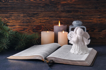 Wall Mural - Book with angel toy on table. Christmas story