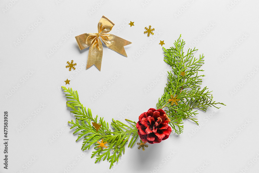 Frame made of fir branches, cone and bow on white background