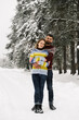 © Vadym - Loving couple in sweaters on a winter walk. Man and woman posing in the frosty forest. Romantic date in winter time.Christmas mood of a young family.Winter lovestory