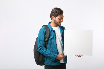 Canvas Print - Young indian college student showing blank sign board on white background.