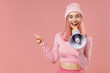 © ViDi Studio - Young woman with dyed rose hair in rosy top shirt hat hold scream in megaphone announces discounts sale Hurry up point index finger aside on workspace isolated on plain light pastel pink background