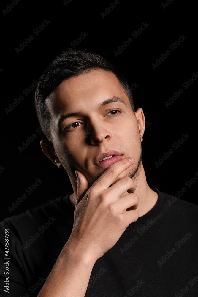 Portrait of handsome young man on black background