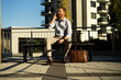 © JustLife - Young stylish businessman sitting on the beanch outdoors. Portrait of handsome man talking to the phone.