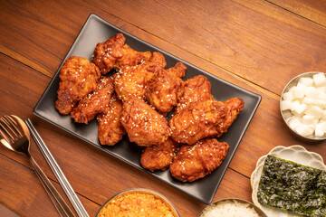 Wall Mural - Traditional Korean food, Korean Fried chicken with spicy sauce  with rice, seaweed and Kimchi pickle on wooden table.