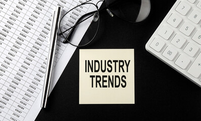 Poster - Concept INDUSTRY TRENDS message on sticker with glasses,chart and calculator on the black background
