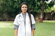 Portrait of confident Indian doctor wearing white coat and stethoscope looking at camera. Medical person during corona virus pandemic in India