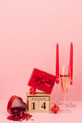 Wall Mural - red gift boxes on calendar with 14 february lettering near champagne in glass, candles and confetti on pink.