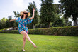 © carles - Woman in straw hat and sunglasses dancing barefoot on the grass