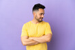 © luismolinero - Young caucasian man isolated on purple background looking to the side and smiling