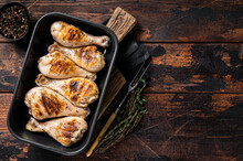 Baked Chicken Legs Drumstick In A Baking Dish With Herbs. Wooden Background. Top View. Copy Space
