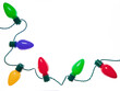 An original holiday photograph of a string of festive colorful Christmas lights on a bright white background with room for text