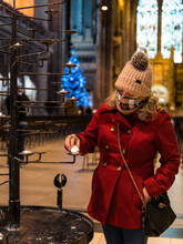 Woman Lights Prayer Candle At The Anglican Cathedral - Liverpool At Christmas