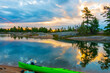Sunset seen  on a rocky campsite on Georgian Bay, Ontario Canada with a green kayak in the foreground.