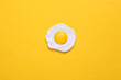 Plastic scrambled eggs on yellow background. Top view. Minimal food concept