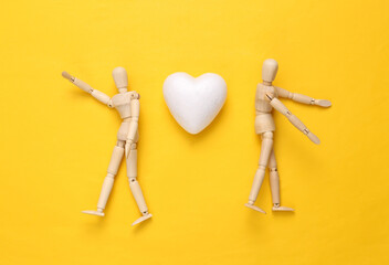 Wall Mural - Two puppets and heart on yellow background. Love concept. Top view