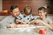 © Татьяна Волкова - Happy family mother, father and son baking Christmas cookies on cozy kitchen at home, Little boy is helping mom and dad in making cookies. Spending time together