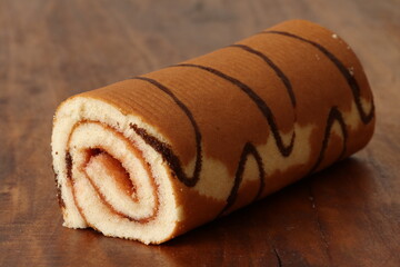 Wall Mural - Sponge cake roll with strawberry filling on a wooden background. Dessert, biscuit roll. 