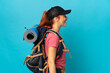 Teenager Russian hiker girl isolated on blue background laughing in lateral position