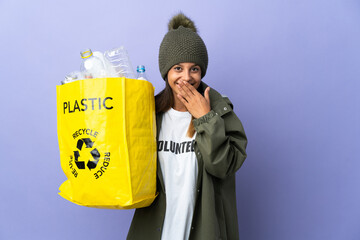 Poster - Young woman holding a bag full of plastic happy and smiling covering mouth with hand