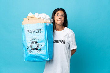 Poster - Young woman holding a recycling bag full of paper and looking up