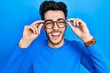 © Krakenimages.com - Young hispanic man wearing glasses smiling and laughing hard out loud because funny crazy joke.